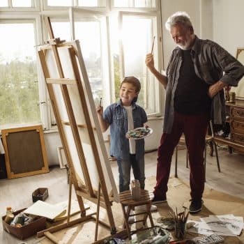 Grandson and grandson painting a canvas together