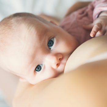 Baby eating mother's milk. Mother breastfeeding baby.