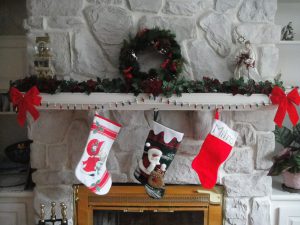 three different stockings hung up on a fireplace.