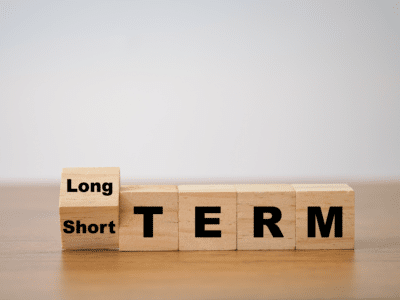 Wooden blocks showing 'Long Term' and 'Short Term' on a table.