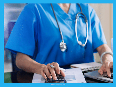 A healthcare professional wearing blue scrubs and a stethoscope works at a desk, using a calculator while reviewing documents with charts. The individual's hands are visible as they also interact with a laptop. The image is framed with a blue border, and the website 'www.ez.insure' is displayed at the bottom.