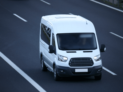 White commercial van driving on the highway.